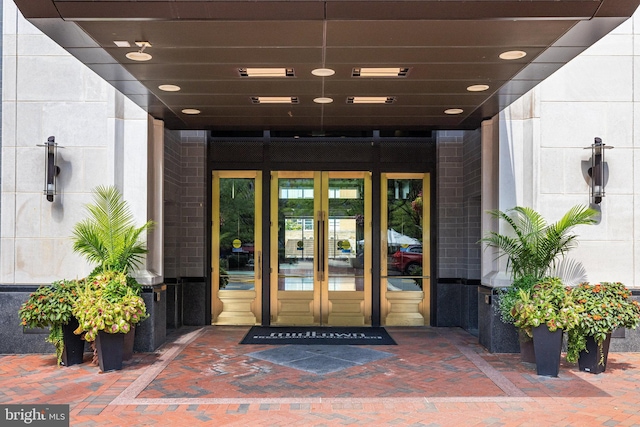 view of exterior entry with brick siding and french doors