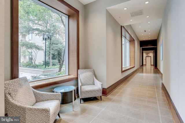 corridor featuring tile patterned floors, visible vents, baseboards, and recessed lighting