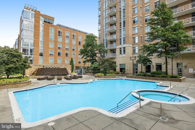 pool with a patio area and a community hot tub