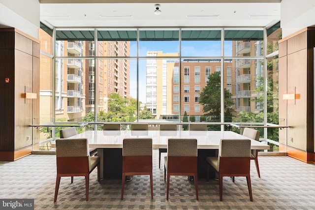 carpeted dining room featuring floor to ceiling windows