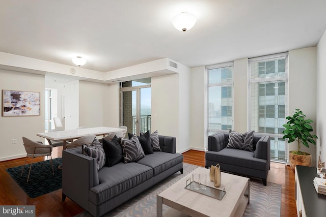 living room featuring visible vents, baseboards, and wood finished floors