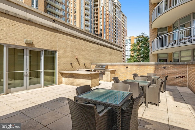 view of patio / terrace with outdoor dining space, exterior kitchen, area for grilling, and french doors