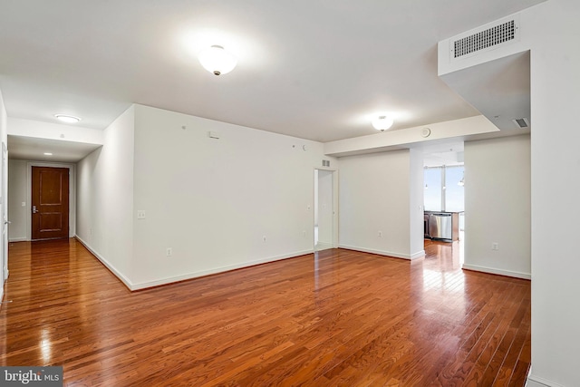 empty room with visible vents, baseboards, and wood finished floors