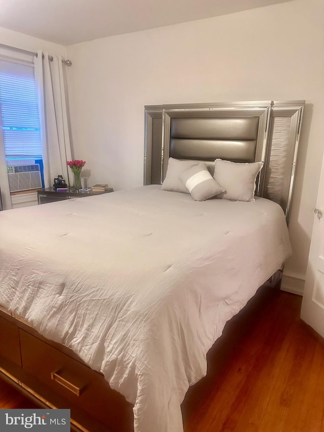 bedroom featuring cooling unit and wood finished floors