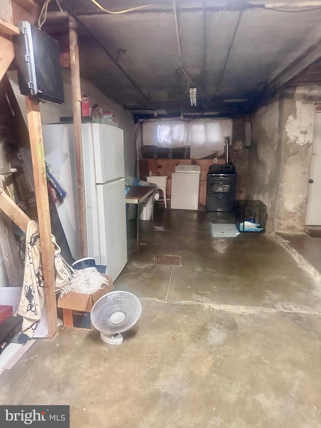 unfinished below grade area with washer / dryer, freestanding refrigerator, and a sink