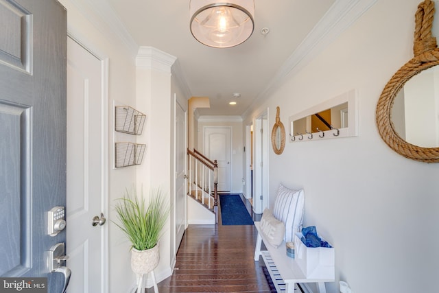 hallway featuring stairway, wood finished floors, baseboards, and ornamental molding