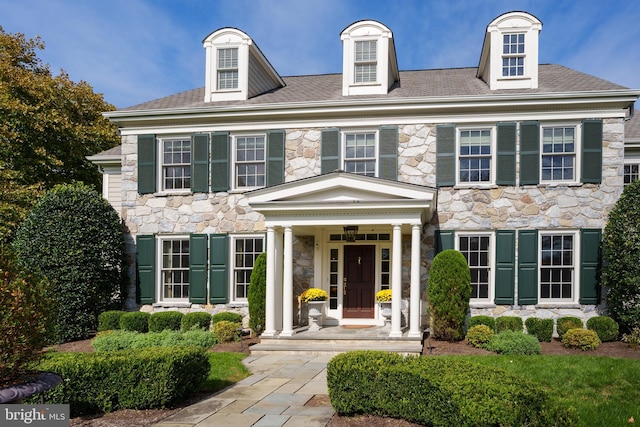 colonial-style house featuring stone siding