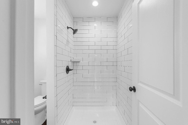 bathroom featuring a stall shower and toilet