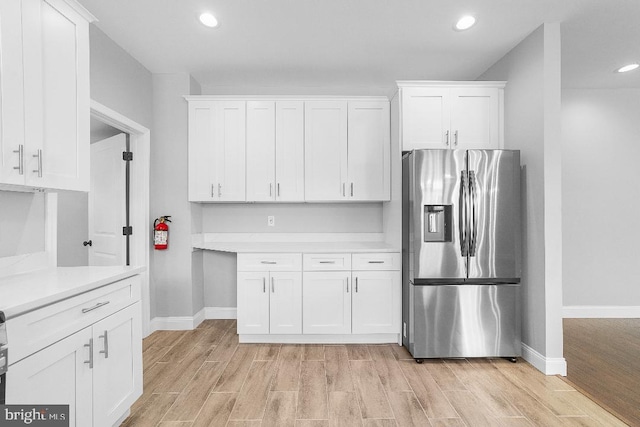 kitchen with white cabinets, light wood finished floors, and stainless steel fridge with ice dispenser