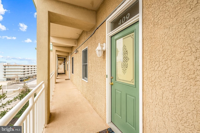 entrance to property with a balcony and stucco siding