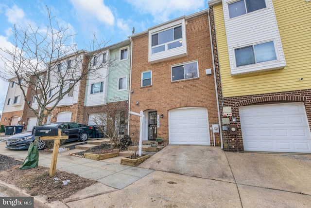 multi unit property featuring a garage, brick siding, and driveway