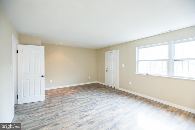 empty room with baseboards and wood finished floors