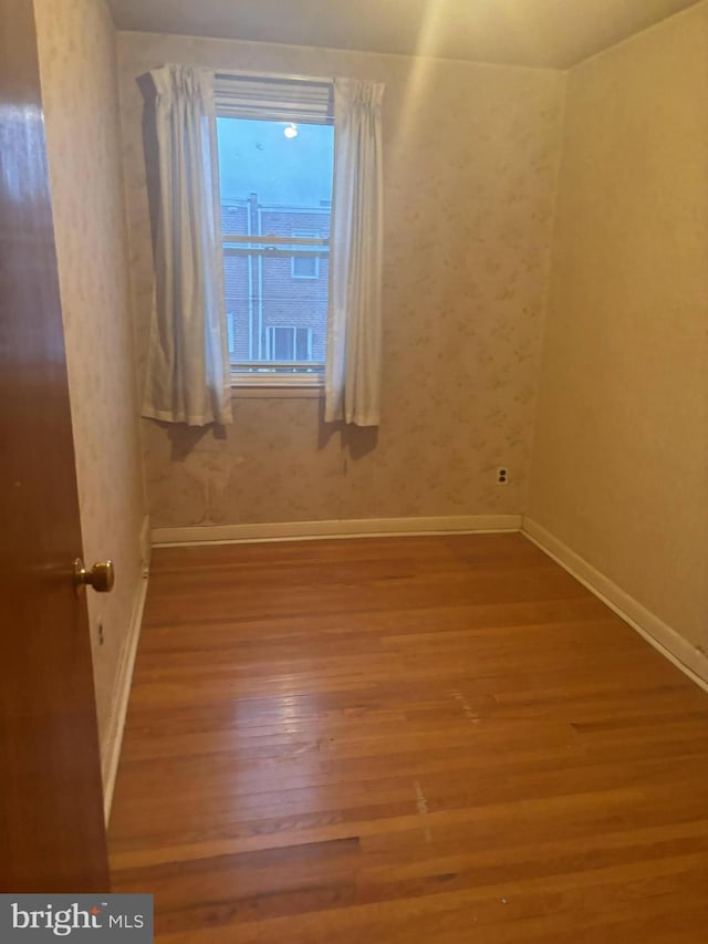 unfurnished room featuring wood finished floors and baseboards