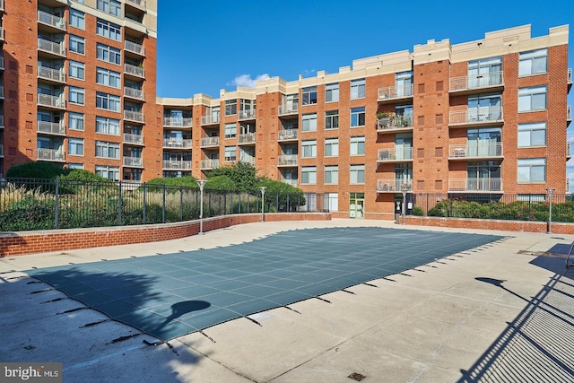 view of swimming pool with a patio and fence