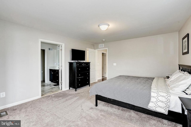 bedroom featuring light carpet, ensuite bathroom, visible vents, and baseboards