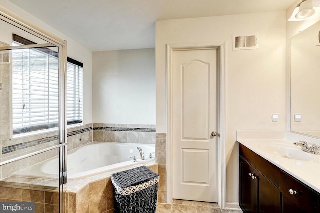 bathroom featuring visible vents, a garden tub, and vanity