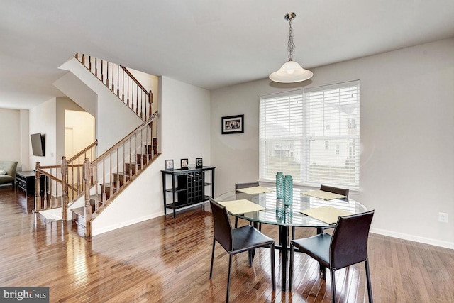 dining room featuring stairs, wood finished floors, and baseboards