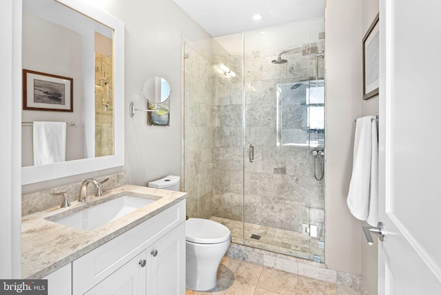 bathroom with a stall shower, vanity, and toilet