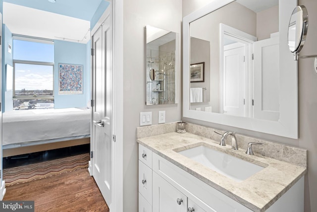 bathroom with vanity, connected bathroom, and wood finished floors