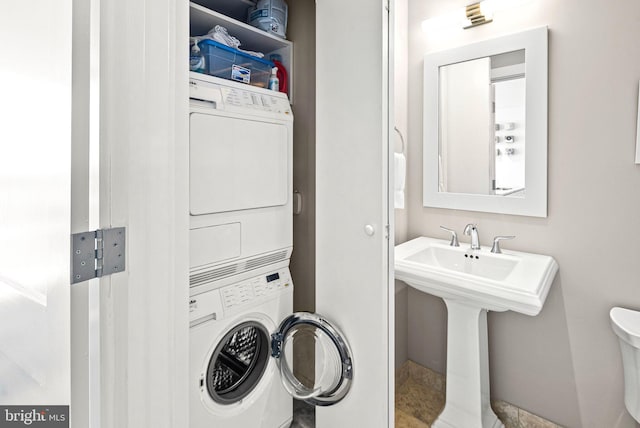 washroom featuring stacked washer and dryer and laundry area