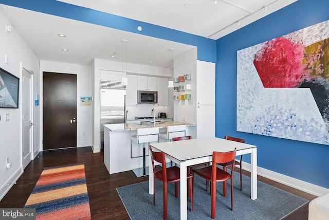 dining space with recessed lighting, dark wood-style flooring, and baseboards