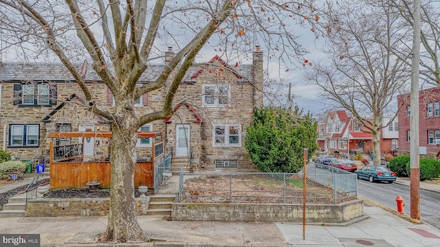 view of property featuring stone siding and a fenced front yard