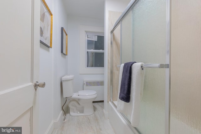 full bath featuring wood finished floors, radiator, toilet, and an enclosed shower