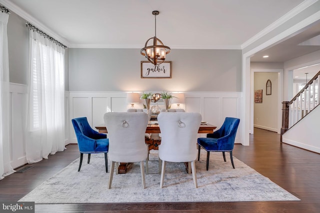 dining area with a chandelier, wood finished floors, stairway, wainscoting, and crown molding