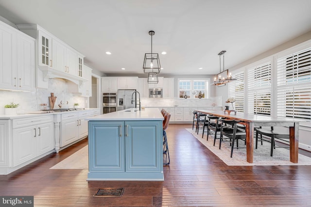 kitchen with stainless steel appliances, dark wood-type flooring, white cabinetry, light countertops, and glass insert cabinets