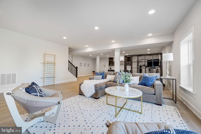 living area featuring recessed lighting, visible vents, stairway, and wood finished floors