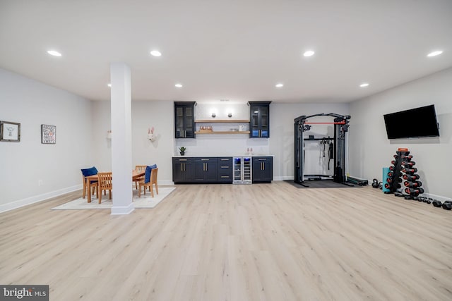 workout room with light wood finished floors, beverage cooler, baseboards, and recessed lighting