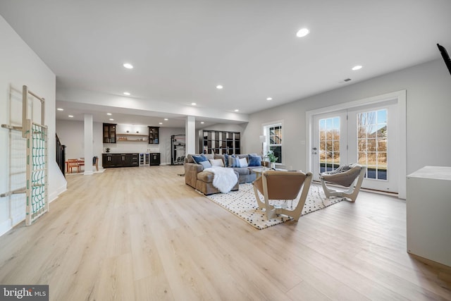 living room featuring recessed lighting, french doors, visible vents, and light wood-style flooring