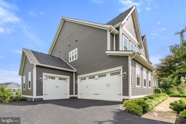 view of property exterior with driveway and an attached garage