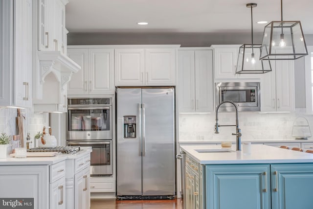 kitchen featuring appliances with stainless steel finishes, white cabinets, and a sink