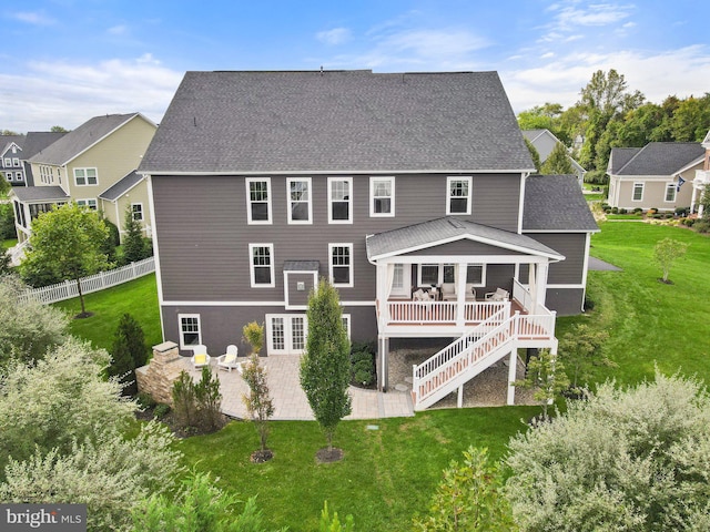 back of property featuring stairs, a patio, a yard, and a shingled roof