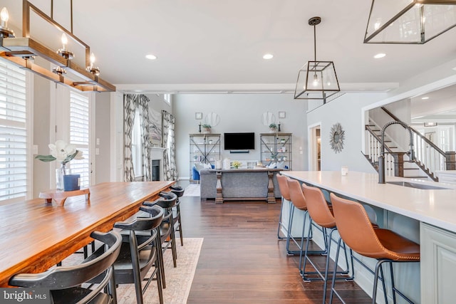 dining area featuring stairs, a fireplace, dark wood finished floors, and recessed lighting