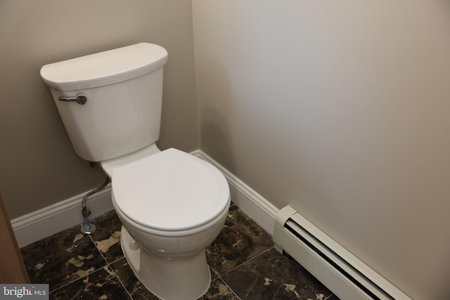 bathroom featuring a baseboard radiator, baseboards, and toilet