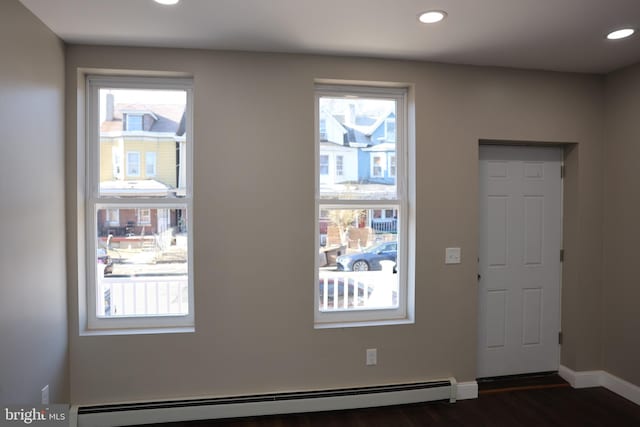 interior space with a wealth of natural light, a baseboard radiator, dark wood-style flooring, and recessed lighting