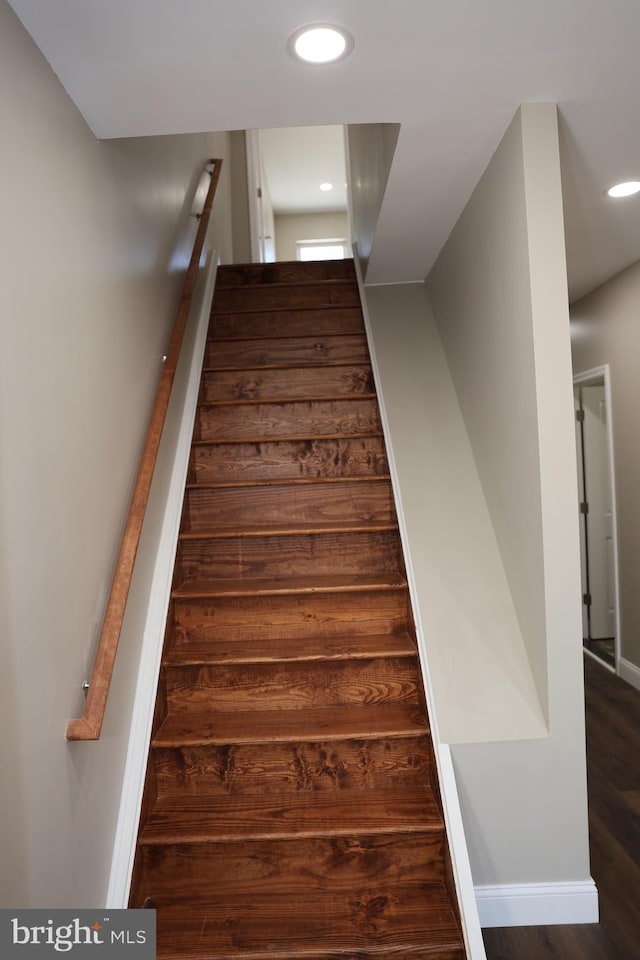 staircase featuring wood finished floors, recessed lighting, and baseboards