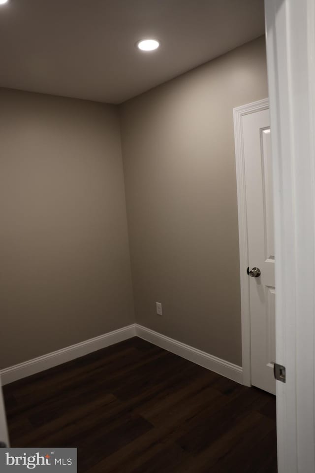 empty room featuring recessed lighting, baseboards, and dark wood-style flooring