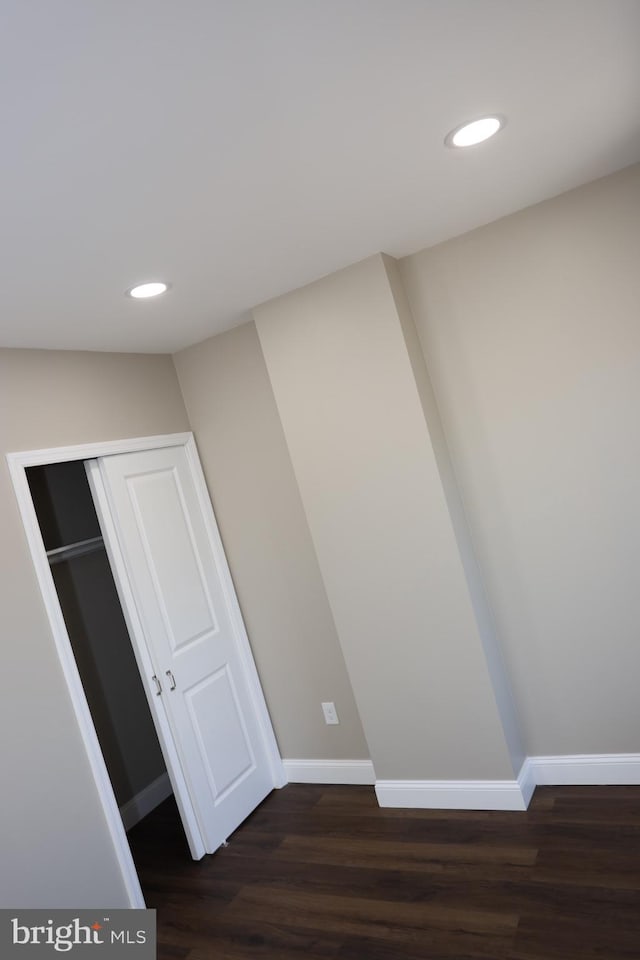 hallway with recessed lighting, baseboards, and dark wood-type flooring