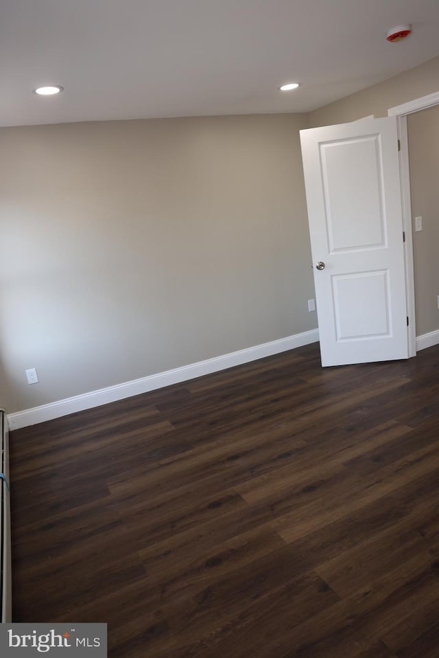 unfurnished room with dark wood finished floors, recessed lighting, and baseboards