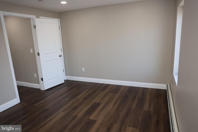 spare room featuring recessed lighting, baseboards, dark wood-style flooring, and a baseboard radiator