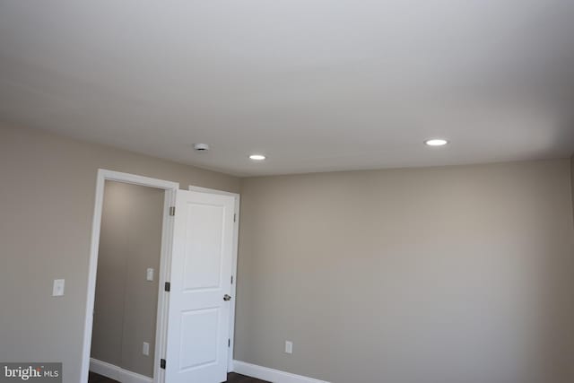 spare room with recessed lighting and baseboards