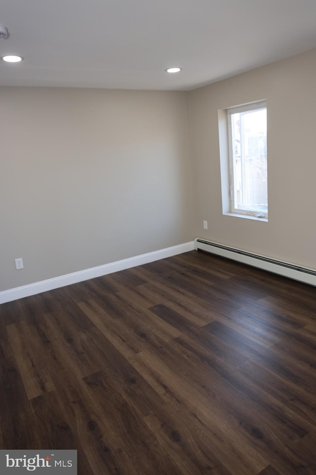 empty room featuring recessed lighting, a baseboard radiator, baseboards, and dark wood-style flooring