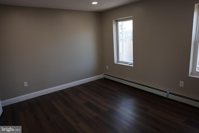 empty room with recessed lighting, a baseboard radiator, baseboards, and dark wood-type flooring