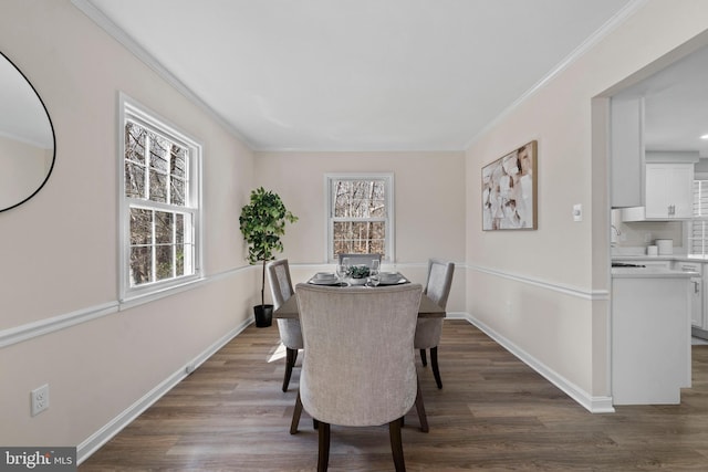 dining area featuring dark wood-style floors, baseboards, and ornamental molding