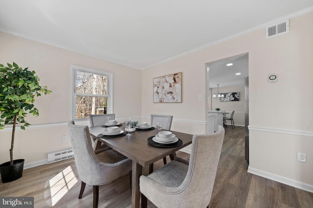 dining area with a baseboard heating unit, visible vents, baseboards, and wood finished floors