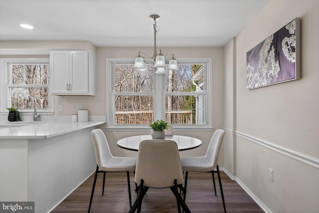 dining room with baseboards, a chandelier, dark wood-type flooring, and recessed lighting