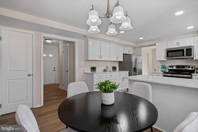 dining space featuring recessed lighting, a notable chandelier, wood finished floors, visible vents, and baseboards